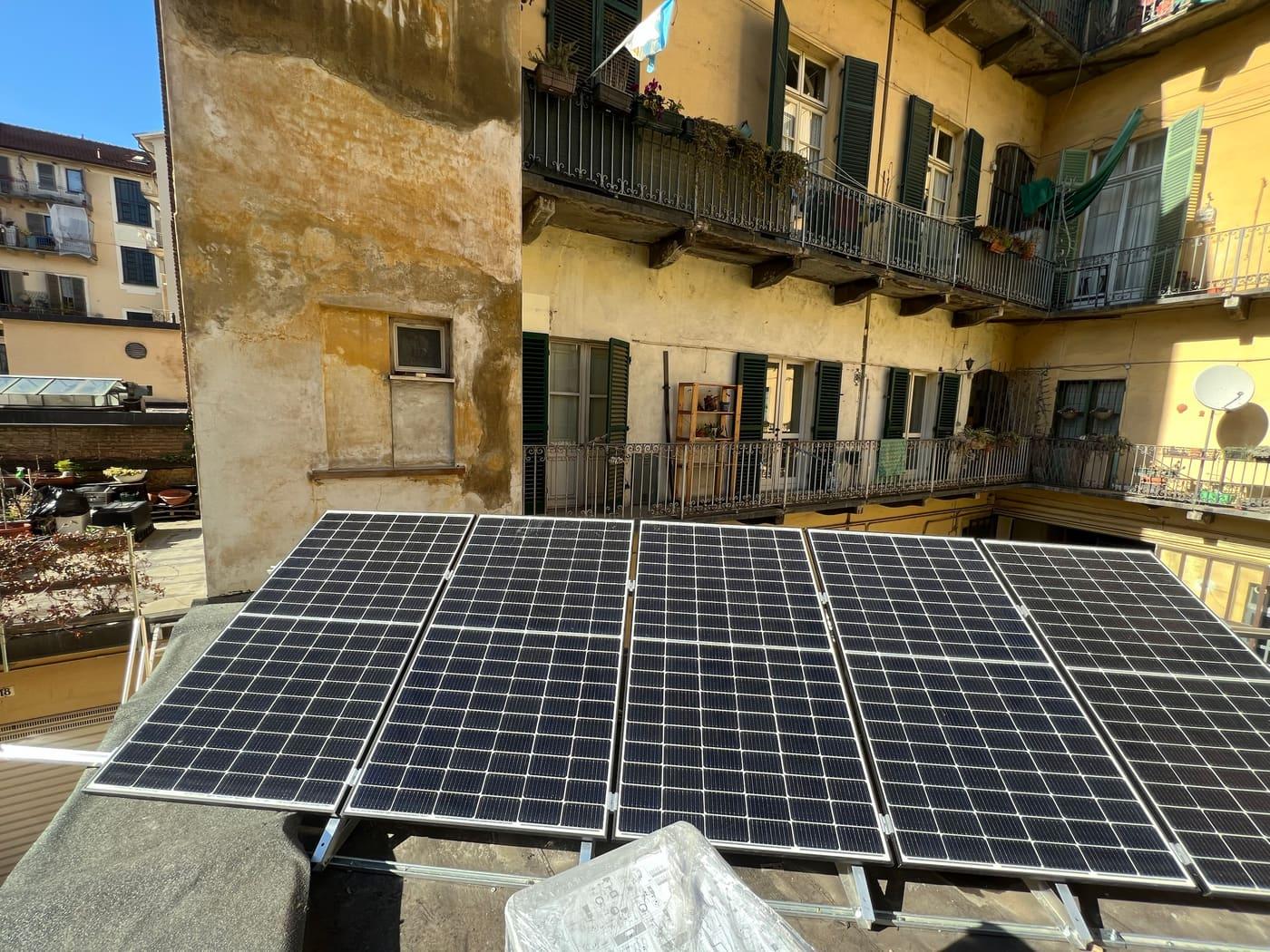 Pannelli fotovoltaici su un terrazzo in un cortile di città, con ballatoi intorno