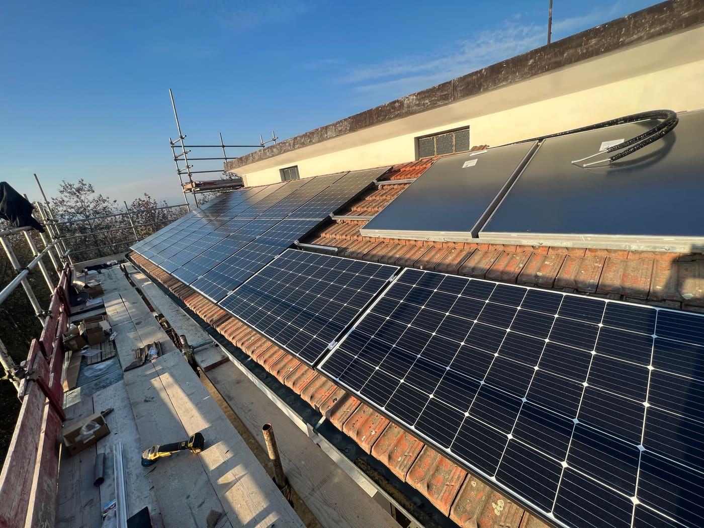 Tetto con pannelli fotovoltaici e collettori solari termici affiancati