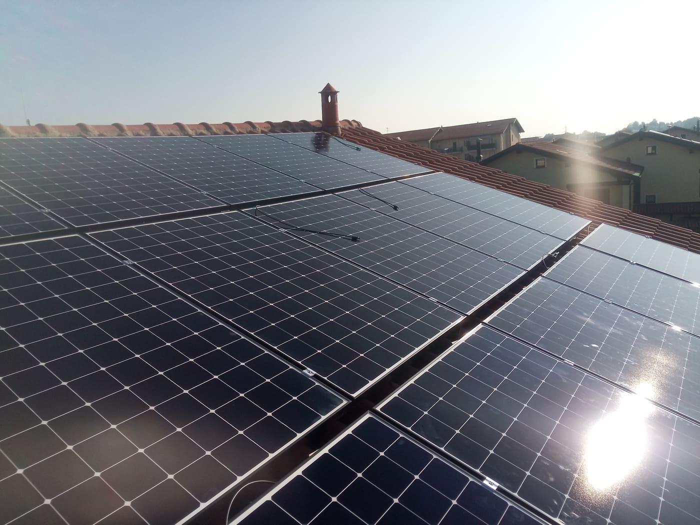 Tetto con pannelli fotovoltaici controluce al tramonto