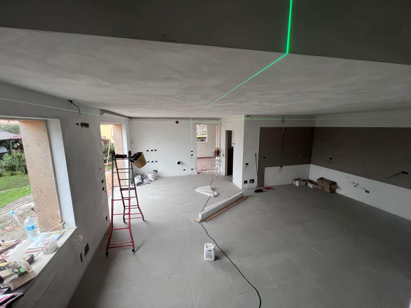 Livello laser verde che proietta linee sul soffitto di una stanza in costruzione