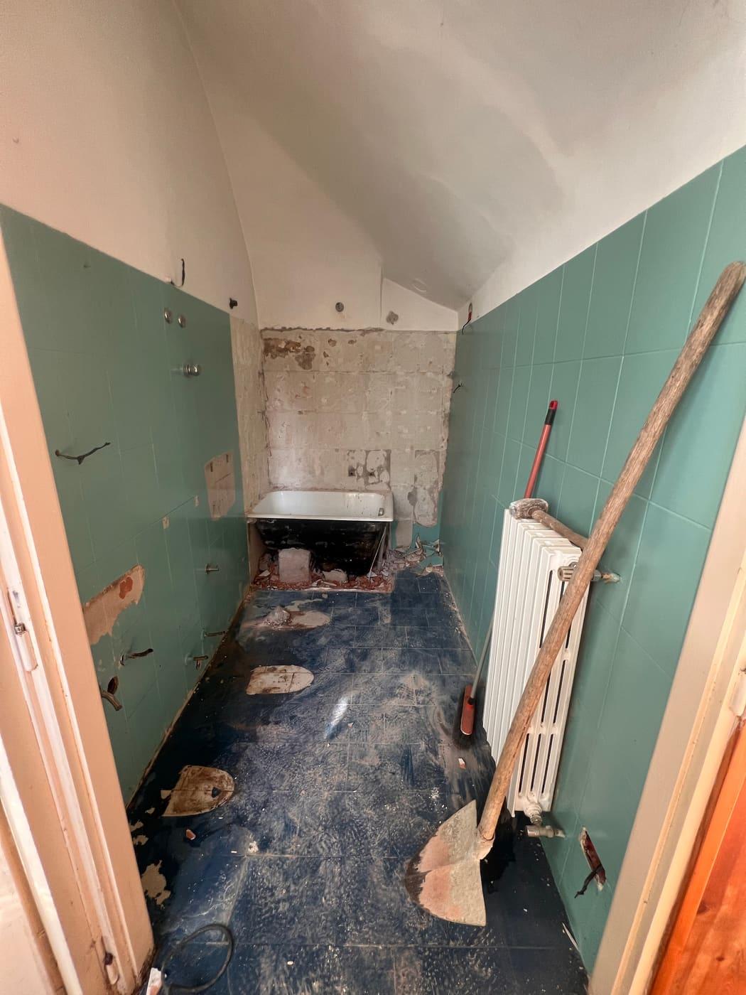 Bagno smantellato durante una ristrutturazione, con vecchie tracce nei muri