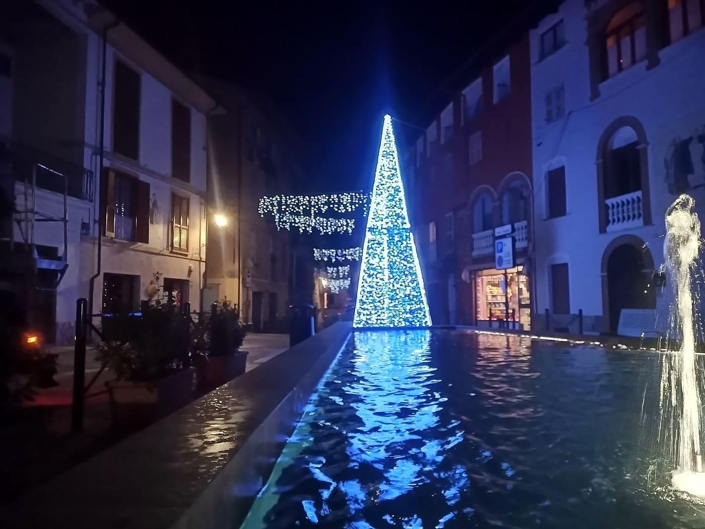 Cono luminoso bianco e azzurro dentro la vasca di una fontana