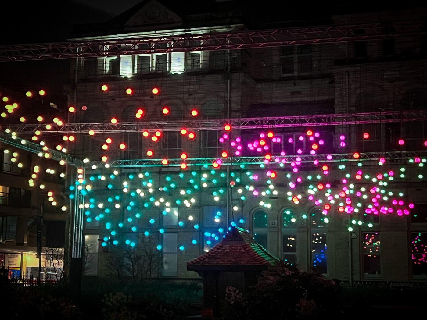 Palazzo di piazza coperto da luci colorate che scendono come pioggia